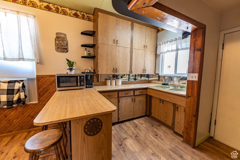 Kitchen featuring sink, kitchen peninsula, and light hardwood / wood-style flooring