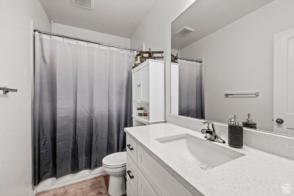 Bathroom featuring tile flooring, toilet, and oversized vanity