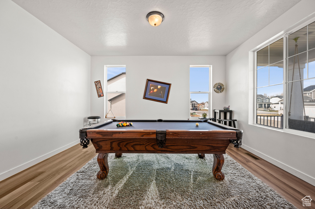 Recreation room featuring plenty of natural light, hardwood / wood-style floors, and billiards