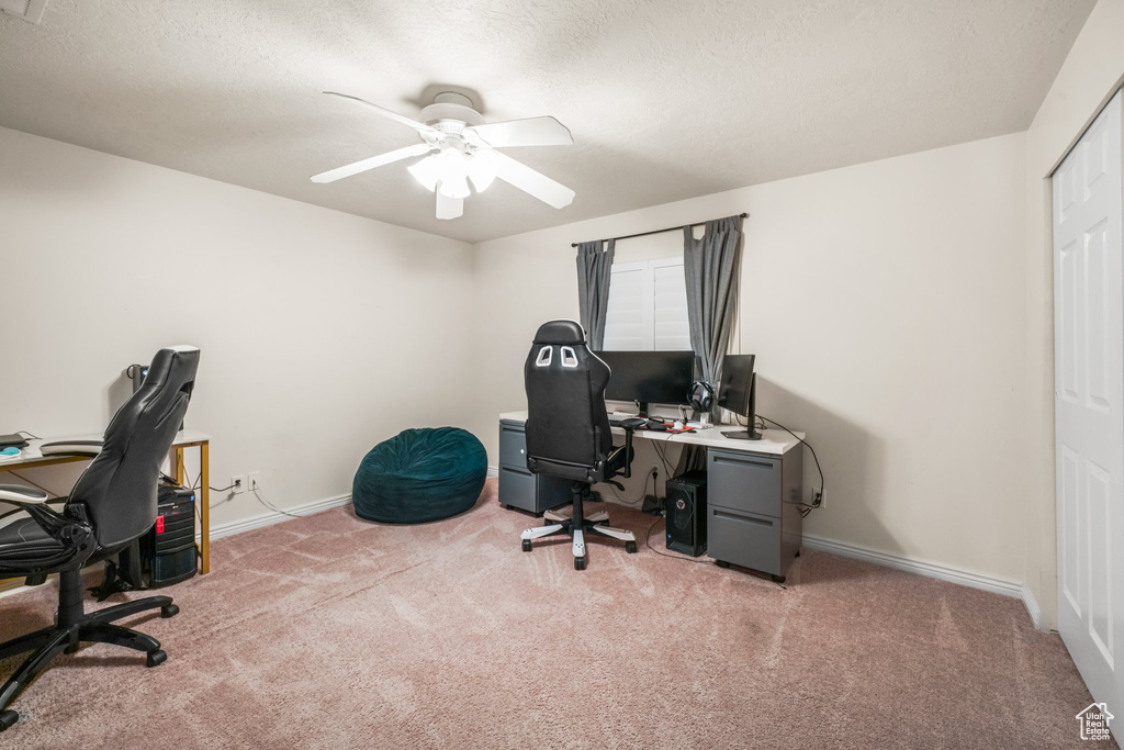 Carpeted office featuring ceiling fan and a textured ceiling