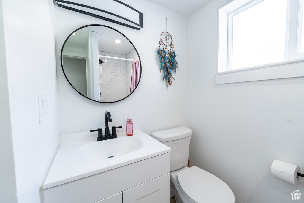 Bathroom with toilet and vanity with extensive cabinet space