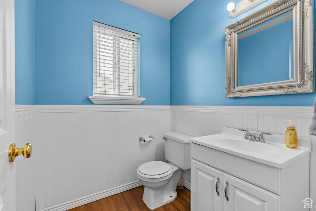 Bathroom with oversized vanity, toilet, and hardwood / wood-style floors