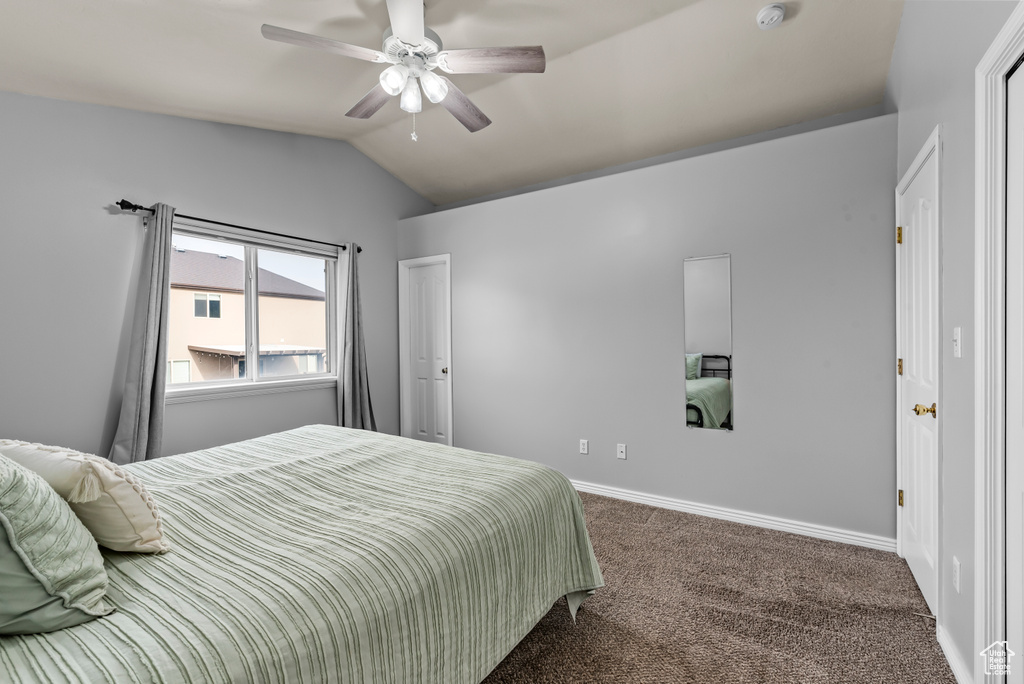 Bedroom featuring lofted ceiling, ceiling fan, and dark colored carpet