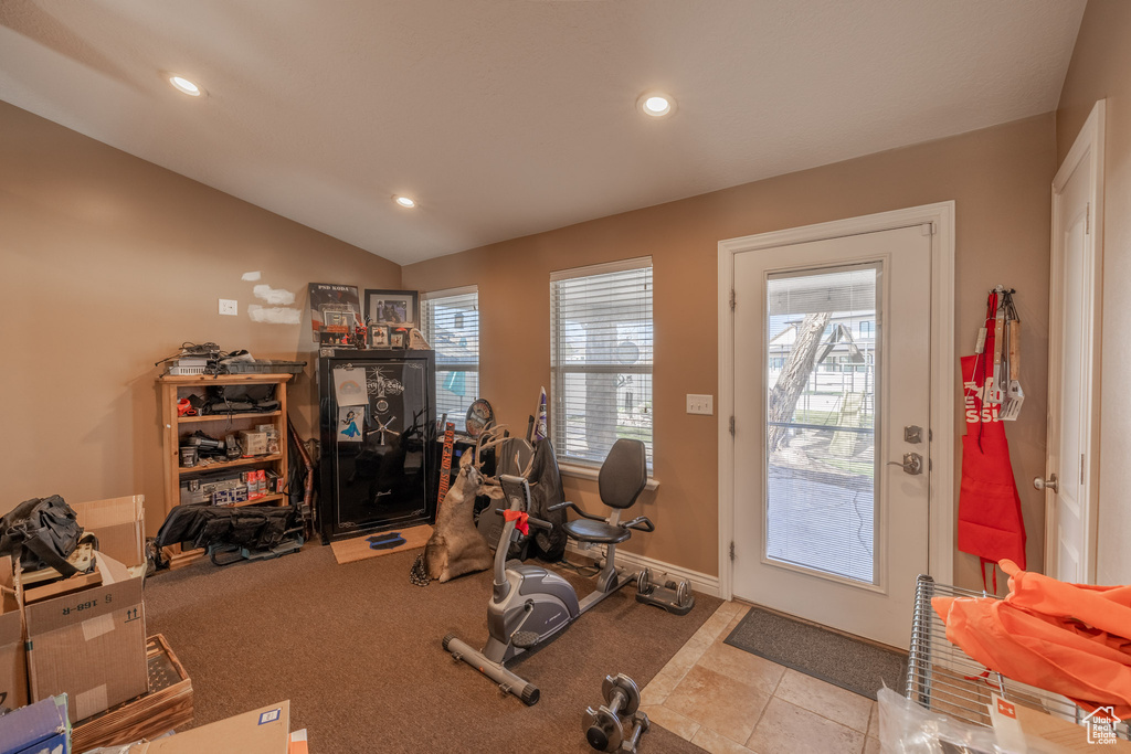 Workout room with light carpet and vaulted ceiling