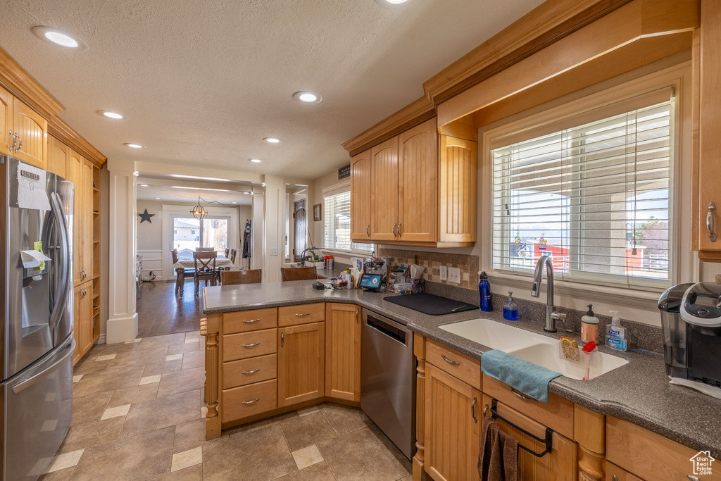 Kitchen with a wealth of natural light, stainless steel appliances, and kitchen peninsula