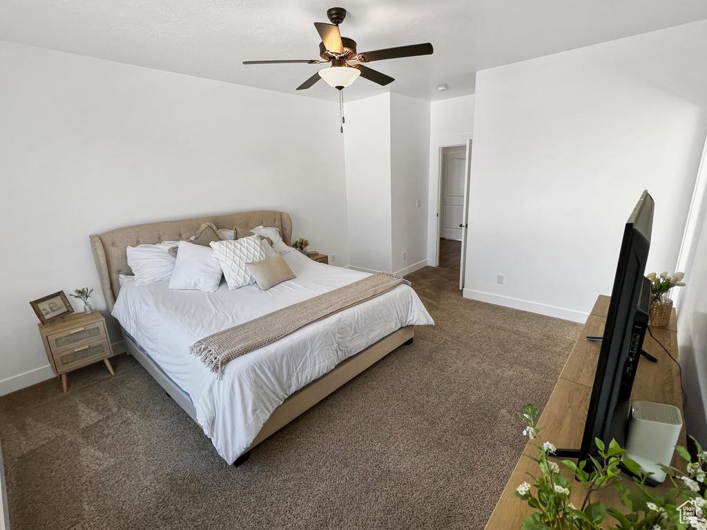 Bedroom featuring ceiling fan and dark colored carpet
