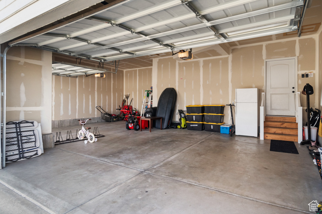 Garage with white fridge and a garage door opener