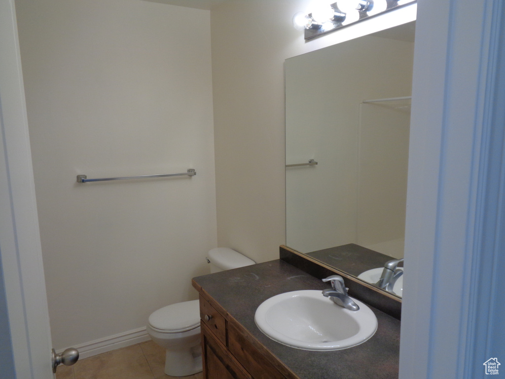 Bathroom featuring tile flooring, toilet, and large vanity