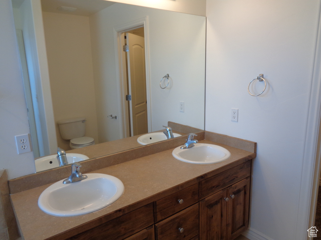 Bathroom with double sink vanity and toilet