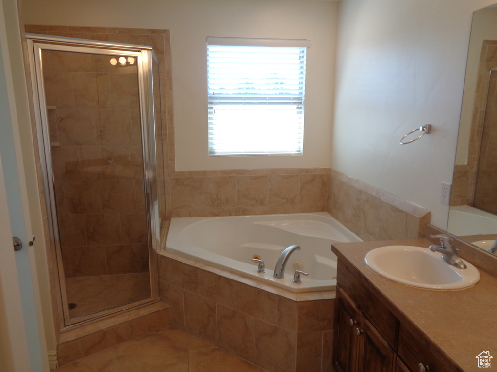 Bathroom with tile floors, vanity, and independent shower and bath