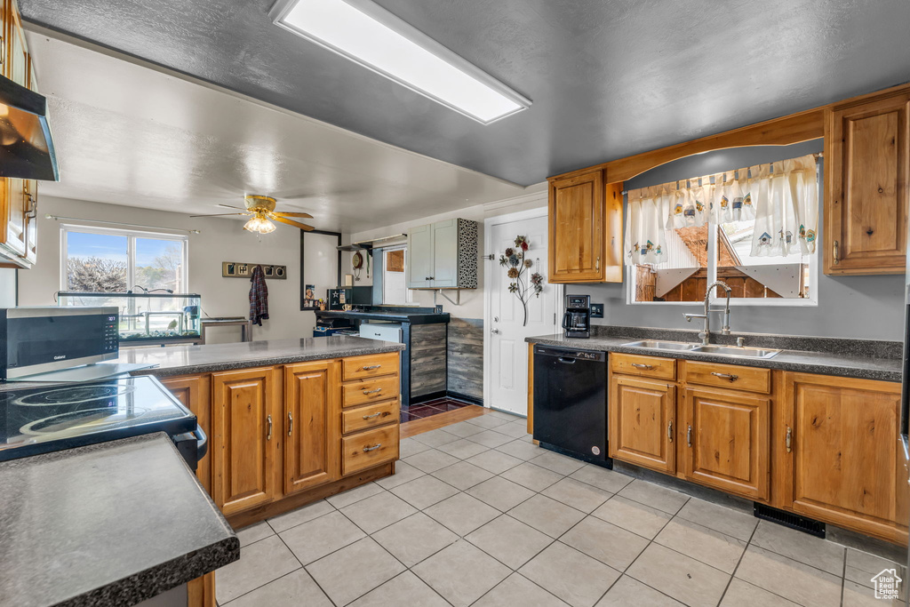 Kitchen with light tile floors, dishwasher, ceiling fan, and sink