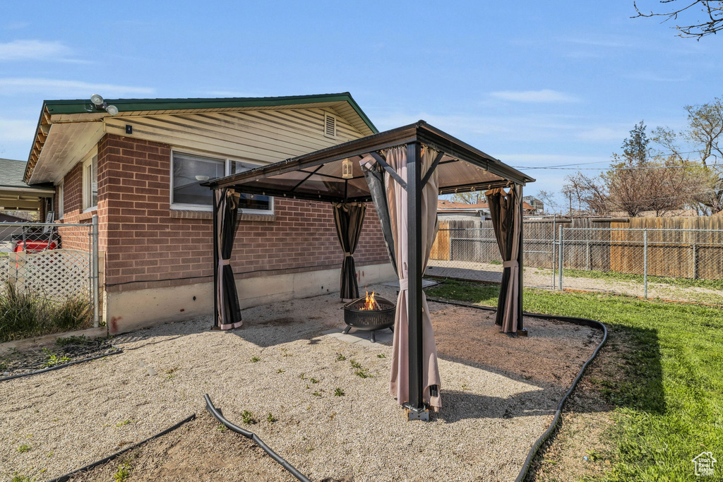 Exterior space with a gazebo and a fire pit