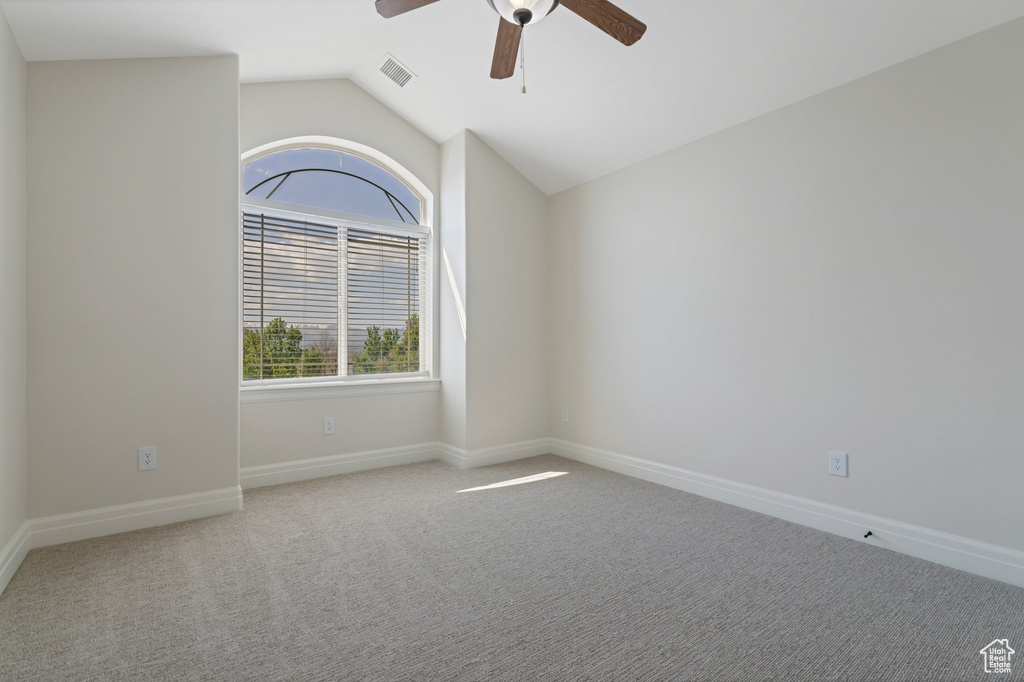 Unfurnished room featuring lofted ceiling, carpet floors, and ceiling fan