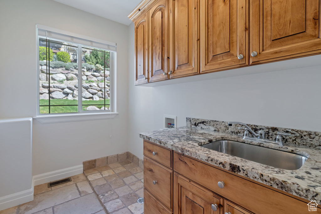 Interior space featuring a healthy amount of sunlight, light stone countertops, and light tile floors