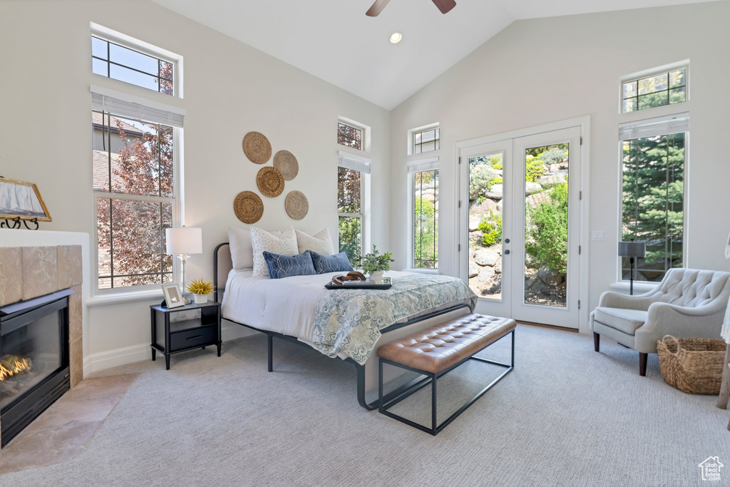 Carpeted bedroom with a fireplace, ceiling fan, access to outside, and multiple windows