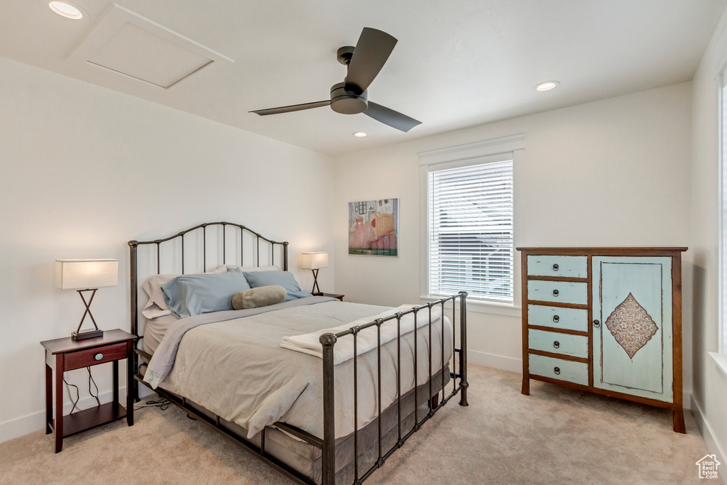 Bedroom with ceiling fan and light carpet