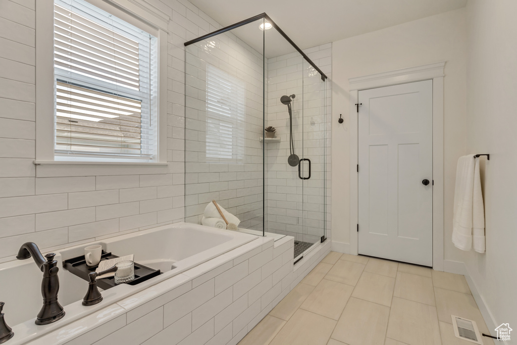 Bathroom featuring tile flooring and separate shower and tub