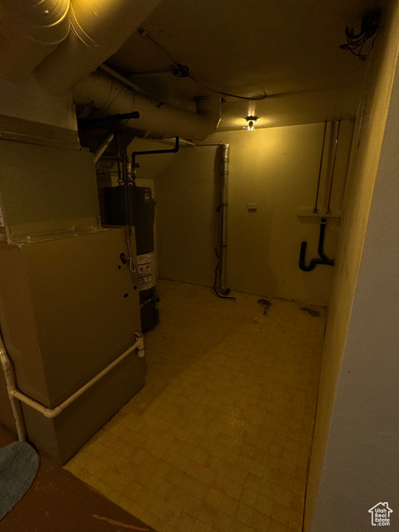 Basement with water heater and light tile floors