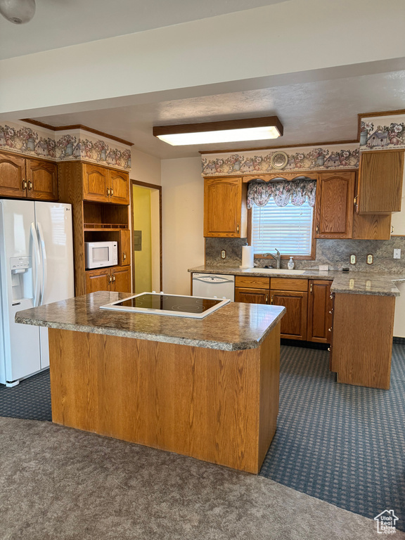 Kitchen featuring backsplash, white appliances, dark carpet, and a center island