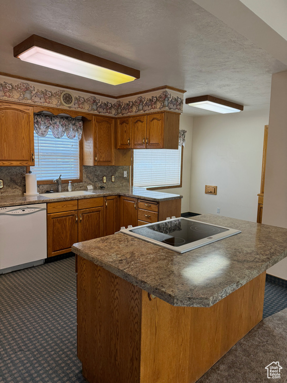 Kitchen featuring dark colored carpet, backsplash, dishwasher, sink, and electric cooktop