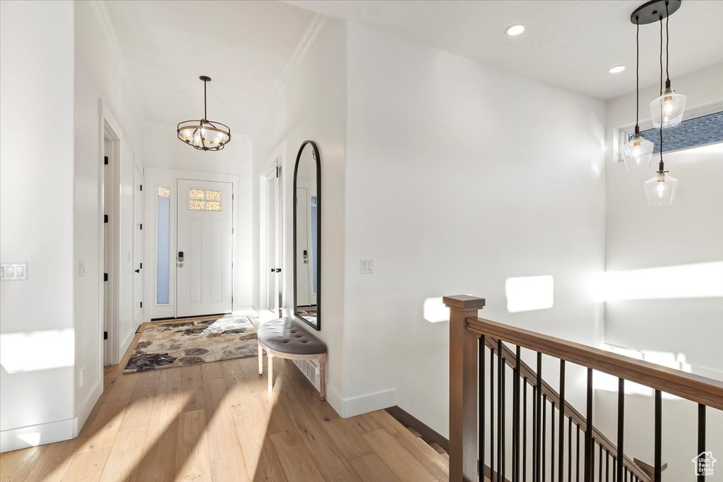 Hallway featuring a notable chandelier and light hardwood / wood-style flooring
