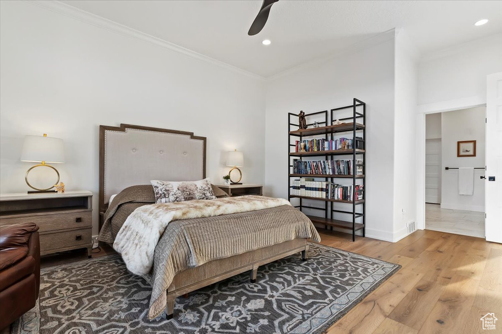 Bedroom featuring ceiling fan, ornamental molding, and wood-type flooring
