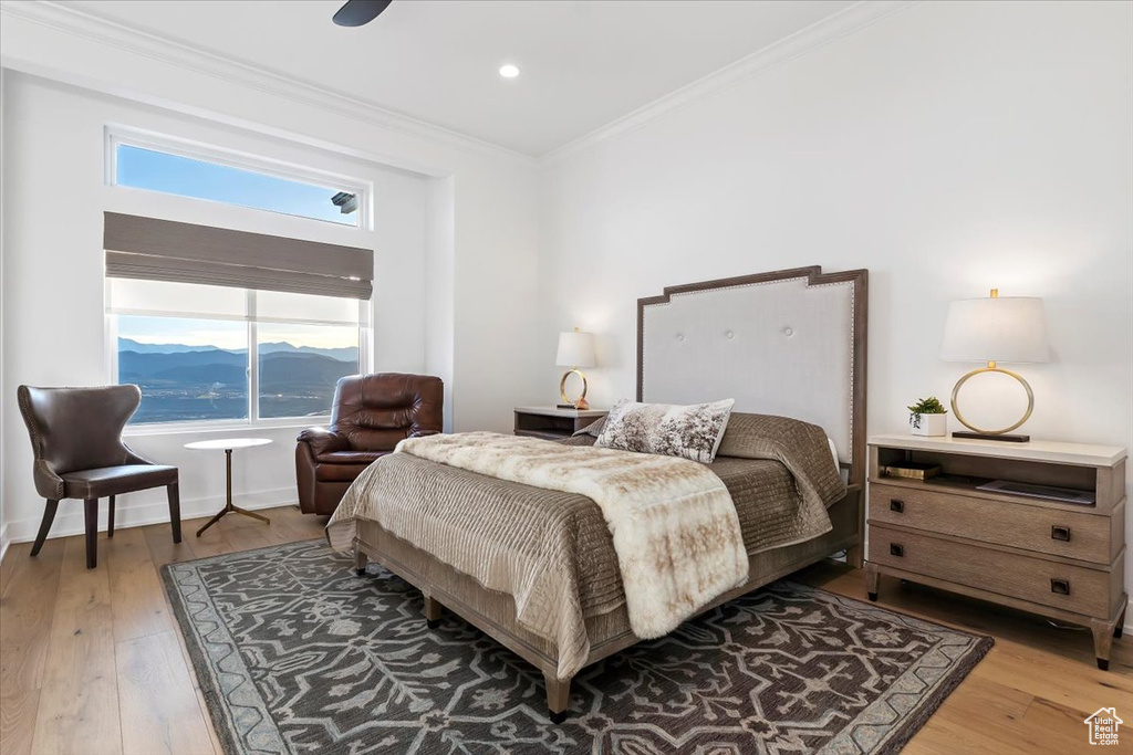 Bedroom featuring crown molding, wood-type flooring, ceiling fan, and a mountain view