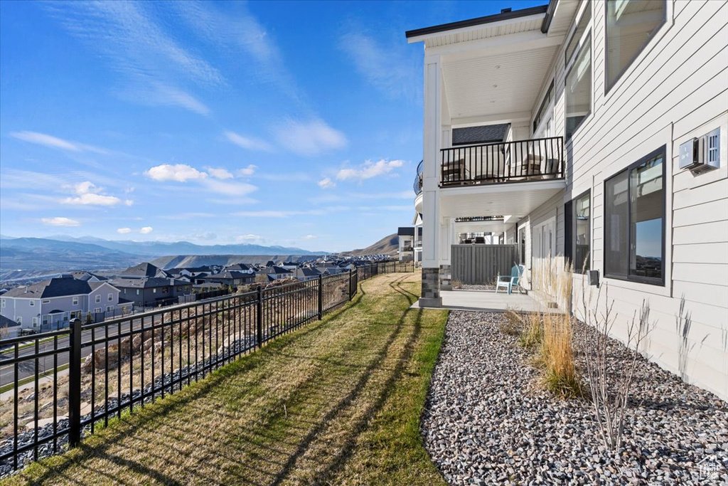 View of yard featuring a balcony, a mountain view, and a patio area