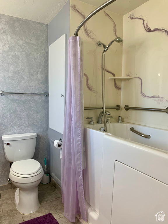 Bathroom with shower / bath combo with shower curtain, toilet, and tile floors
