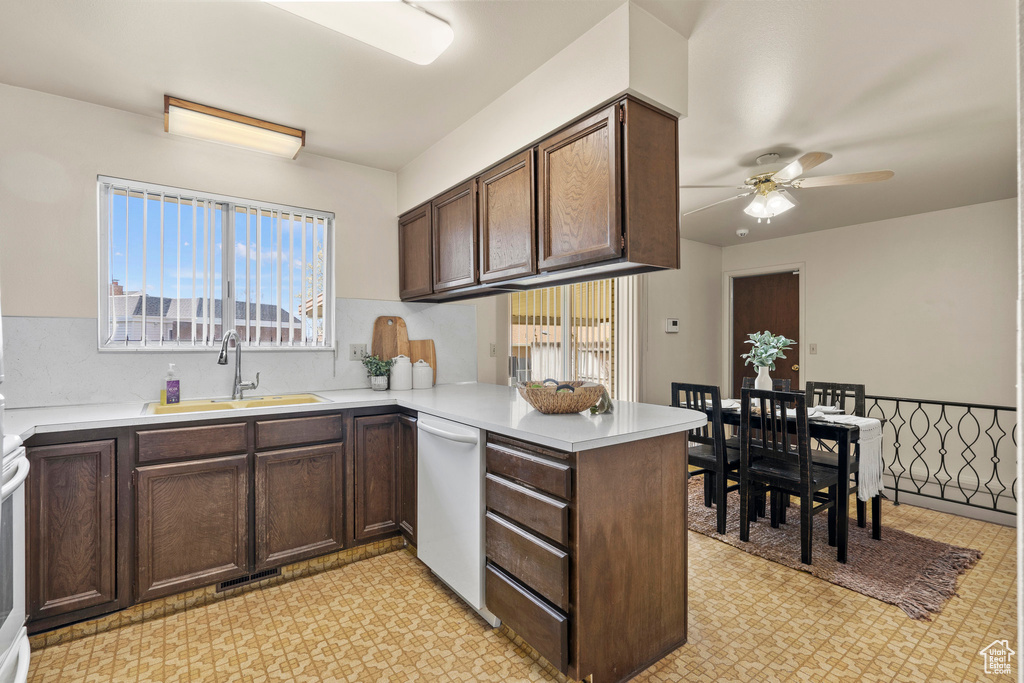 Kitchen featuring dark brown cabinets, kitchen peninsula, ceiling fan, sink, and white dishwasher