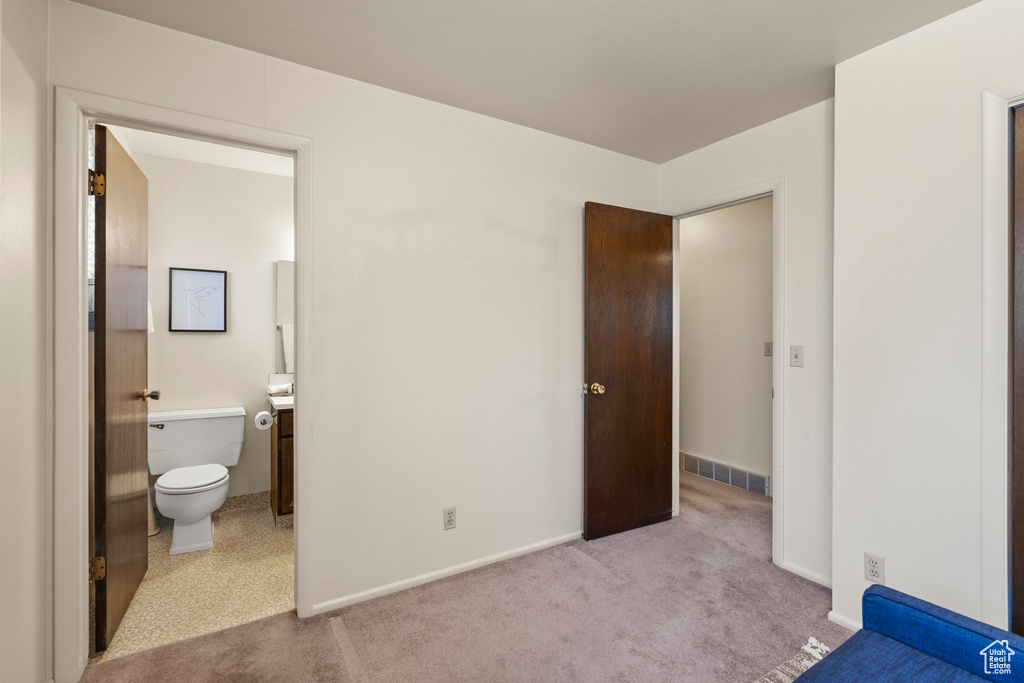 Unfurnished bedroom with light colored carpet and ensuite bath