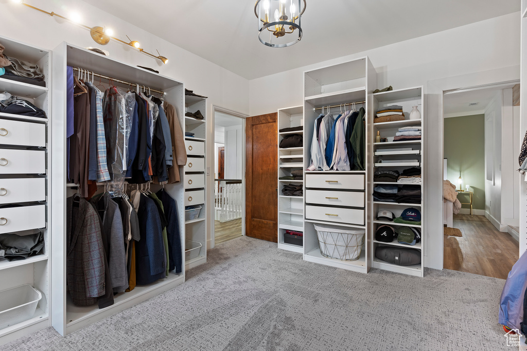 Walk in closet featuring light colored carpet and a chandelier