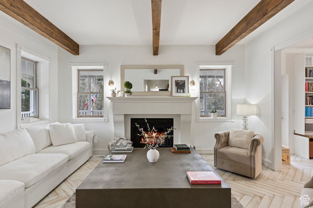 Living room featuring light parquet floors, a wealth of natural light, and beam ceiling