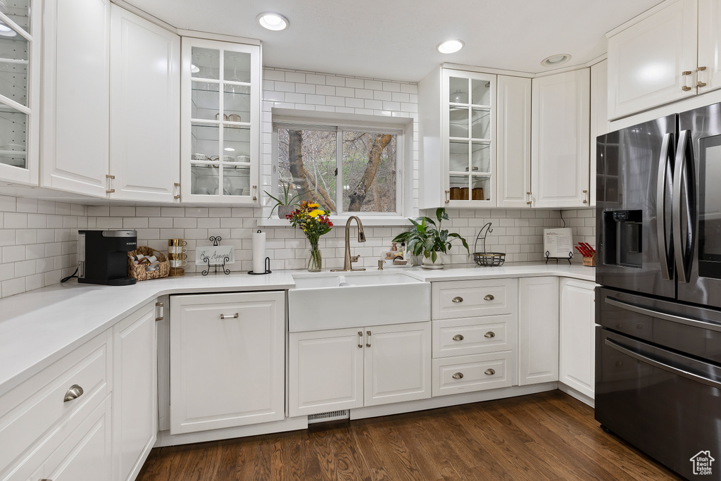Kitchen with sink, white cabinets, stainless steel refrigerator with ice dispenser, and dark wood-type flooring
