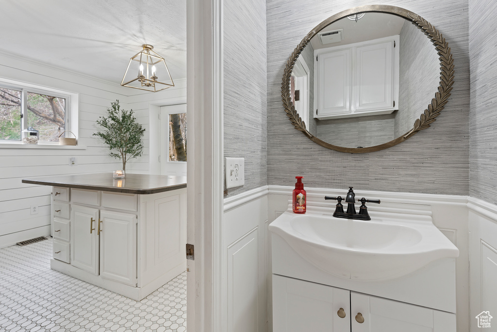 Bathroom featuring tile floors, a chandelier, and vanity