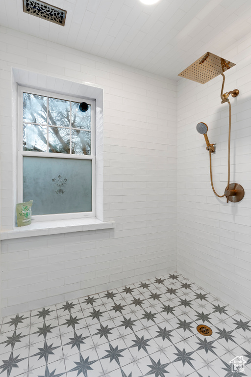 Bathroom featuring tiled shower and tile floors