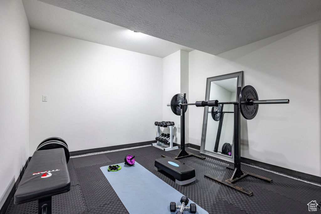 Workout area featuring a textured ceiling and carpet