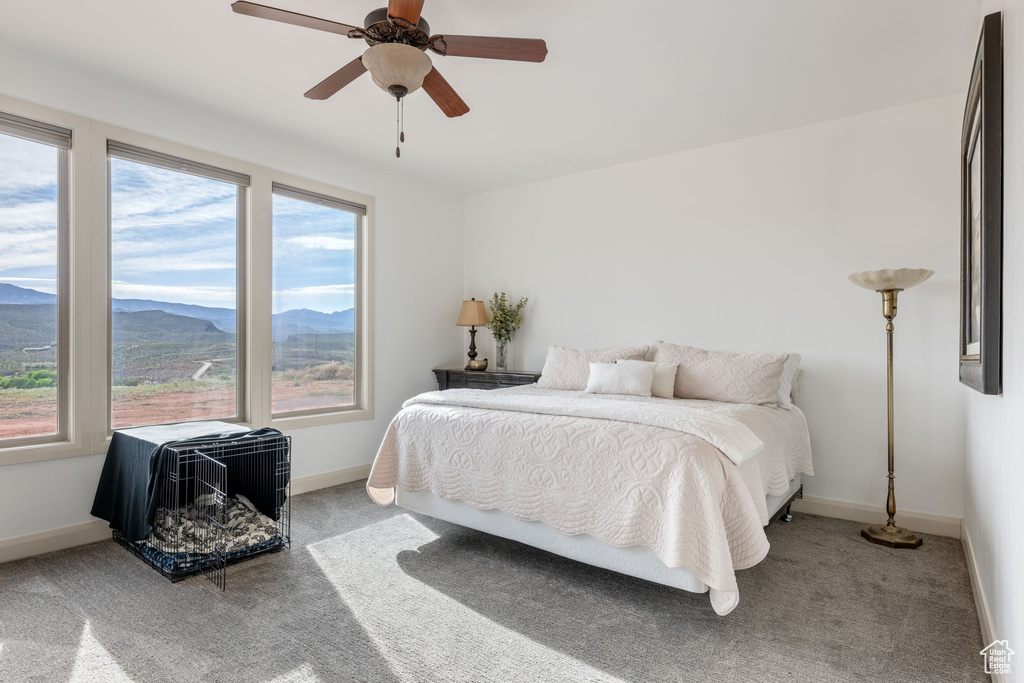 Carpeted bedroom featuring ceiling fan and a mountain view