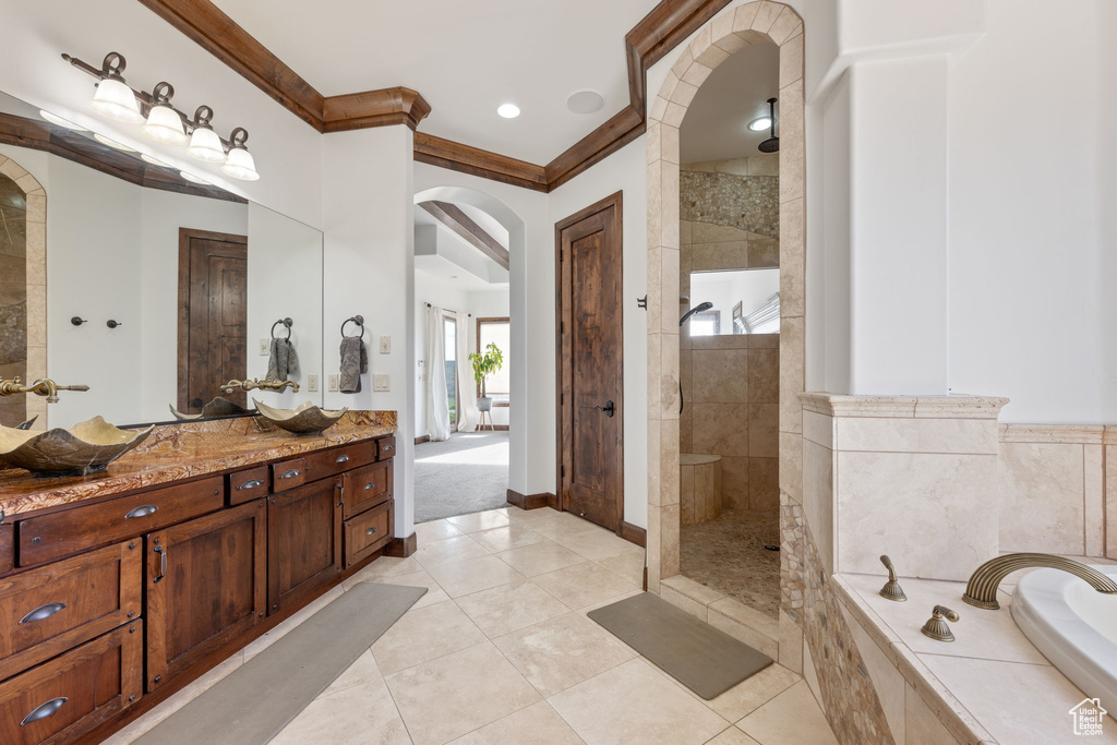 Bathroom featuring tile floors, ornamental molding, plus walk in shower, and vanity