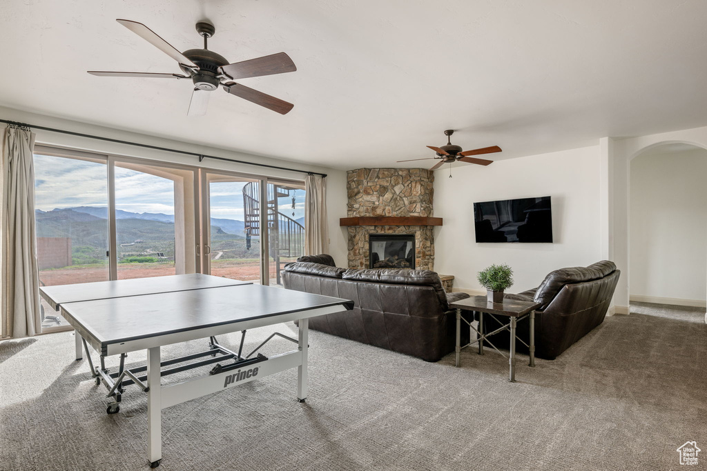 Playroom featuring ceiling fan, carpet floors, a fireplace, and a mountain view