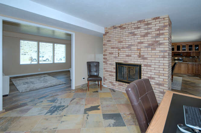 Interior space featuring brick wall and a fireplace