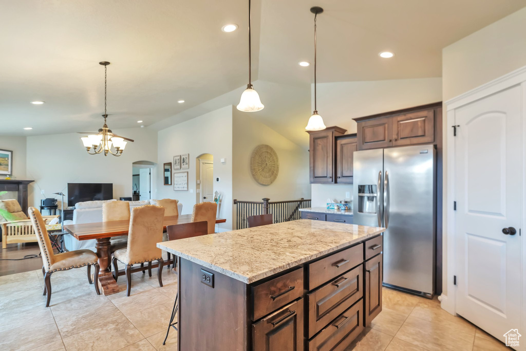 Kitchen featuring a notable chandelier, a center island, stainless steel refrigerator with ice dispenser, and decorative light fixtures
