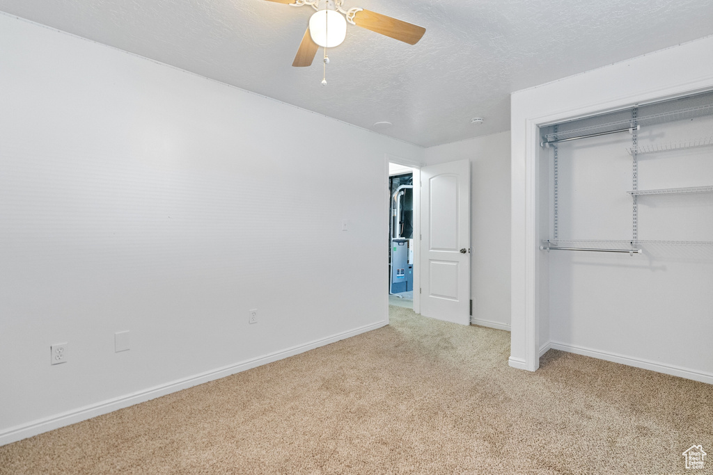 Unfurnished bedroom with a closet, ceiling fan, and light colored carpet