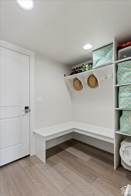 Mudroom with a textured ceiling and light wood-type flooring