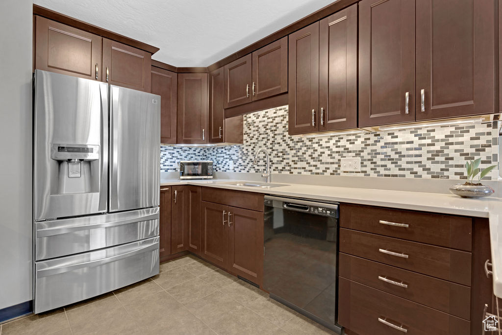 Kitchen with backsplash, light tile floors, sink, stainless steel refrigerator with ice dispenser, and black dishwasher