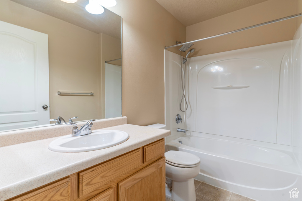 Full bathroom with tile flooring, toilet, washtub / shower combination, and oversized vanity