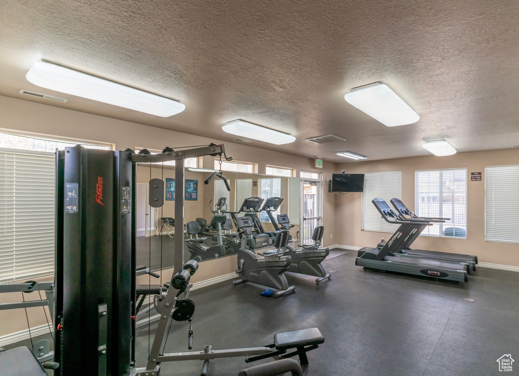 Workout area with a textured ceiling and plenty of natural light