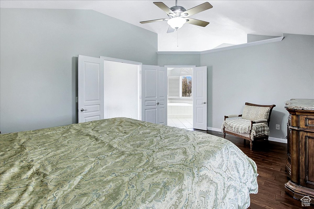 Bedroom featuring ceiling fan, lofted ceiling, dark wood-type flooring, and ensuite bathroom