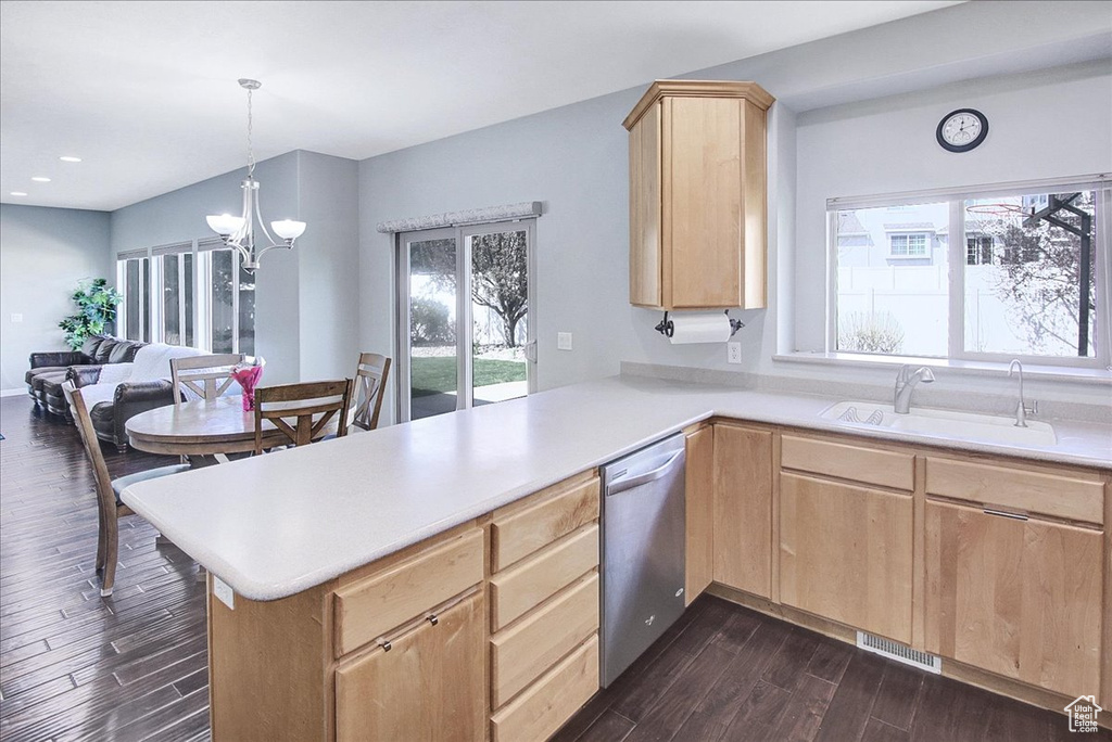 Kitchen with an inviting chandelier, dishwasher, dark hardwood / wood-style flooring, sink, and kitchen peninsula