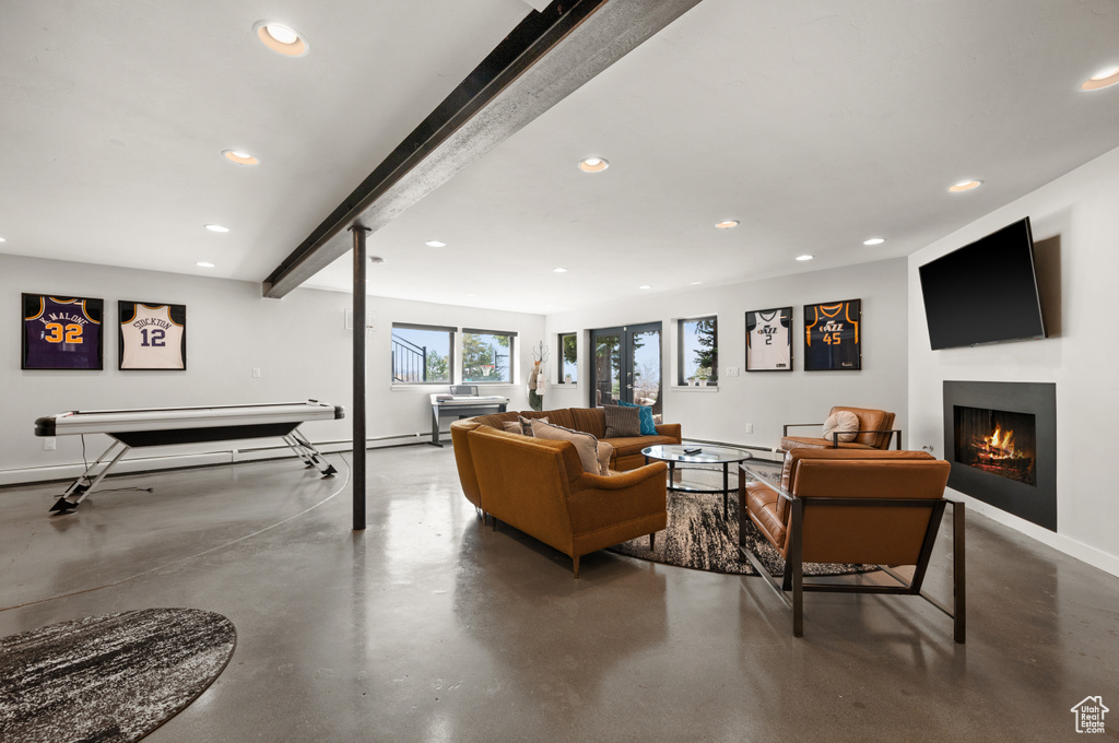 Living room featuring beamed ceiling and concrete flooring